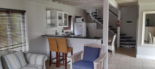 cocina con encimera y sillas en una habitación en 83 @ The Dunes, en Plettenberg Bay