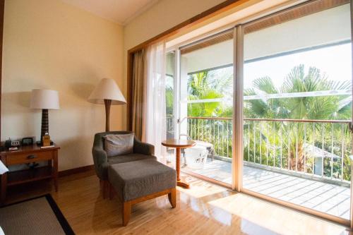a living room with a chair and a large window at Mandarin Oriental, Sanya in Sanya