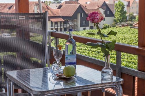 a bottle of wine and a flower on a table at Hotel Restaurant Hansjakob in Hagnau