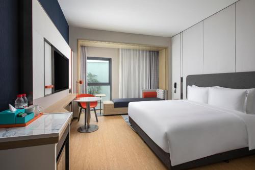 a bedroom with a large white bed and a desk at Holiday Inn Express Beijing Yizhuang Center by IHG in Beijing