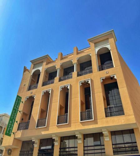 a tall building with windows and a blue sky at Garden City Hotel Dubai in Dubai
