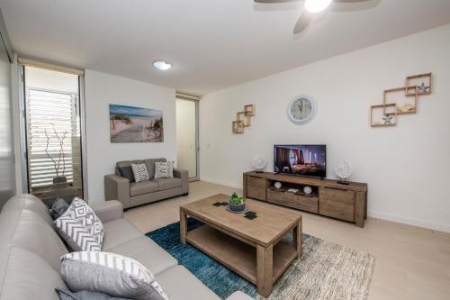 a living room with a couch and a tv at Bright Point 1308 at Magnetic in Nelly Bay