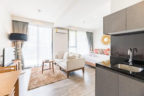 a kitchen and living room with a couch and a table at The Deck patong Luxury Apartments The Deck patong in Patong Beach