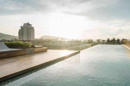 a swimming pool in a building with the sun shining at The Deck patong Luxury Apartments The Deck patong in Patong Beach