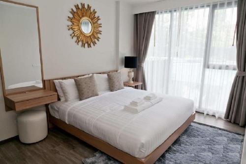 a bedroom with a large bed with a mirror on the wall at The Deck patong Luxury Apartments The Deck patong in Patong Beach