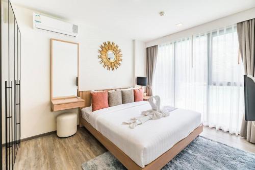 a bedroom with a large bed and a mirror at The Deck patong Luxury Apartments The Deck patong in Patong Beach