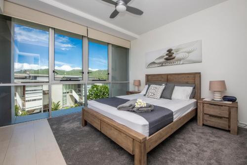 a bedroom with a bed and a large window at Bright Point 1308 at Magnetic in Nelly Bay