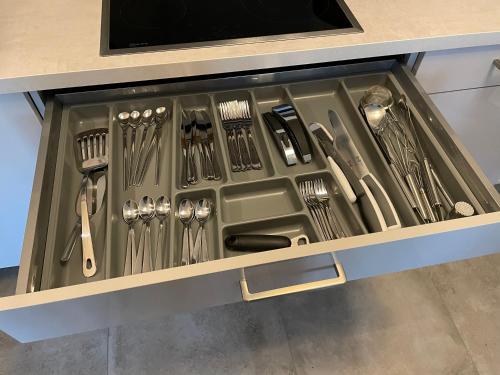 a drawer filled with utensils in a kitchen at Moderne Ferienwohnung / Top City- u. Wasserlage am Yachthafen Bad Zwischenahn in Bad Zwischenahn