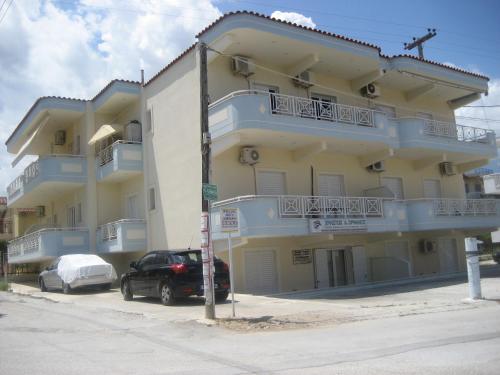 a large building with a car parked in front of it at Almare (Τρίκλινο Δωμάτιο) in Káto Almirí