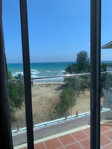 a view of the beach from a window at Nilaveli Beach Apartment Sri Lanka in Nilaveli