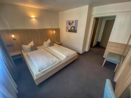 a bedroom with a large bed and a chair at City Partner Hotel Berliner Hof in Karlsruhe