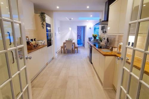 a hallway with a kitchen and a dining room at South Coast Seaside Holiday Home -3 BED-GF-Sleeps 8-Free Parking-Walk to Beach-Private Garden- Families-Professional Groups-Contractors WELCOME in Bournemouth