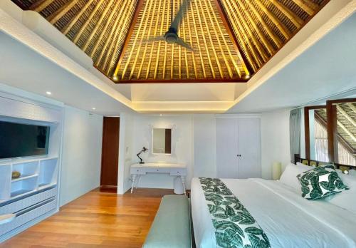 een slaapkamer met een bed en een plafond met een dakraam bij Calm Villa in Seminyak