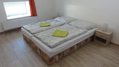 a bedroom with a bed with two green pillows on it at Penzion U Hradeb in Znojmo