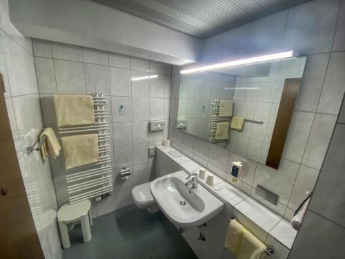 a white bathroom with a sink and a mirror at City Partner Hotel Berliner Hof in Karlsruhe