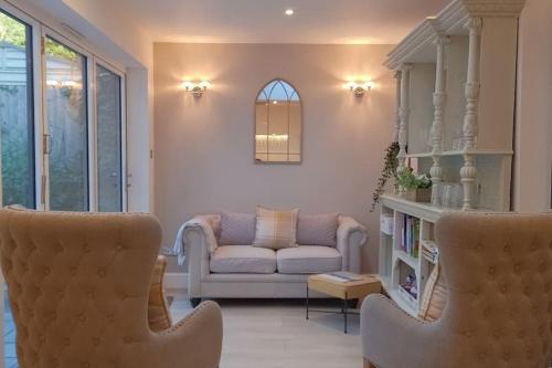 sala de estar con sofá y silla en Large family Apartment, walking distance to beach with Private Garden & Parking, en Bournemouth