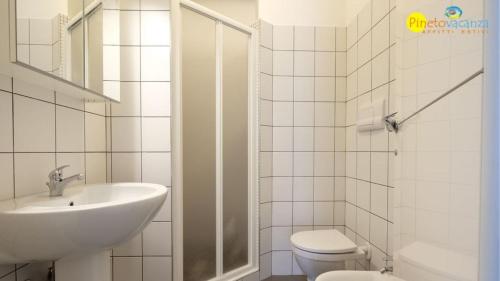 een witte badkamer met een wastafel en een toilet bij Mango 2 Pineto Vacanza in Pineto