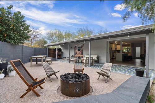 a patio with two chairs and a fire pit at Mid-Century Stunner // Large Yard and Patio for Indoor/Outdoor Living in Phoenix