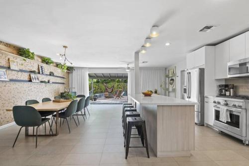 a kitchen with a table and chairs and a dining room at Mid-Century Stunner // Large Yard and Patio for Indoor/Outdoor Living in Phoenix