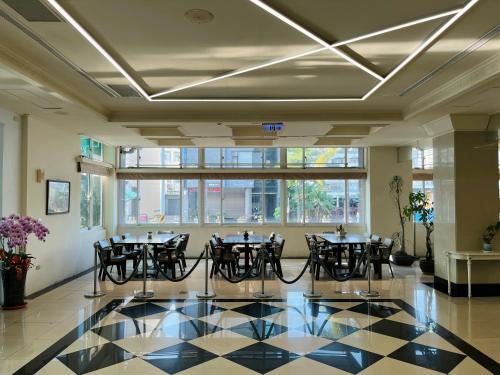 a dining room with tables and chairs and windows at Sendale Tainan Science Park Hotel in Xinshi