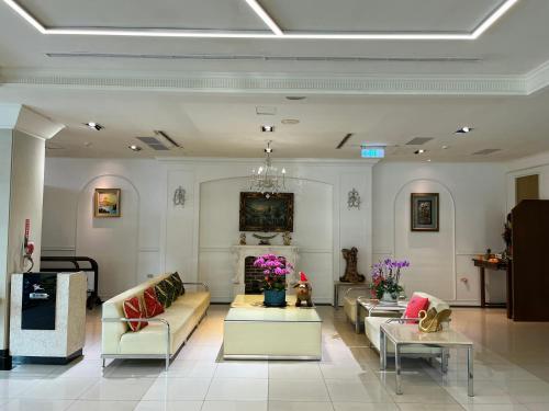 a living room with couches and tables and a chandelier at Sendale Tainan Science Park Hotel in Xinshi