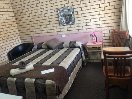 una camera da letto con un letto con un teschio sul muro di Alamo Motor Inn a Nyngan