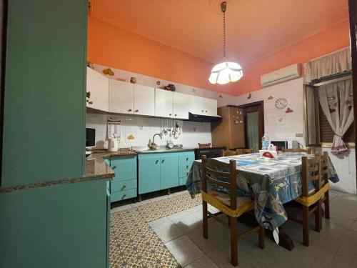 uma cozinha com uma mesa e alguns armários azuis em Big Mom House em Palermo