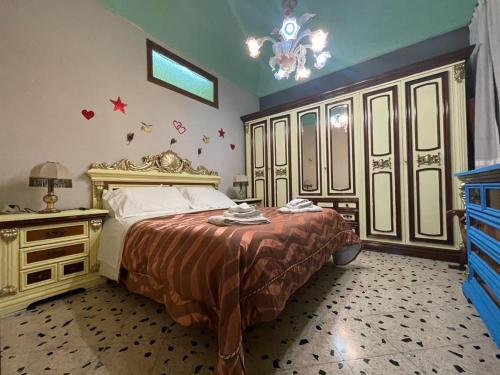 um quarto com uma cama grande e um lustre em Big Mom House em Palermo
