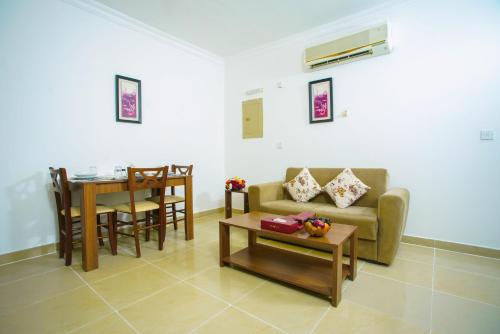 a living room with a couch and a table at La Villa Inn Hotel Apartment in Doha