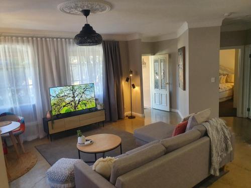 a living room with a couch and a tv at Hahndorf House B&B in Hahndorf