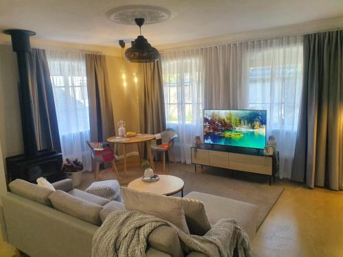 a living room with a couch and a flat screen tv at Hahndorf House B&B in Hahndorf