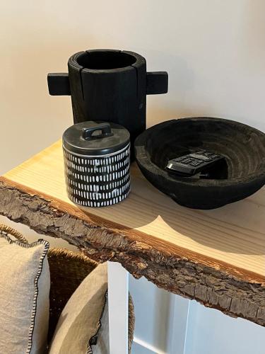 a wooden table with a black bowl on top of it at Le S in Argelès-sur-Mer