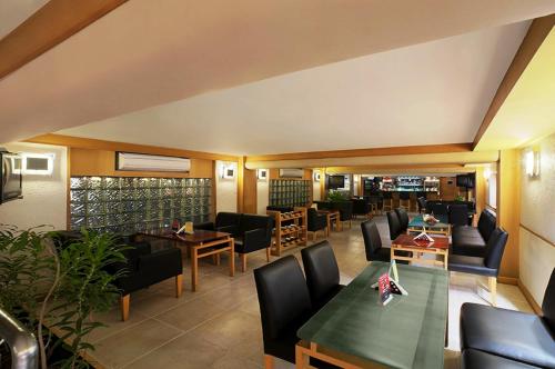a dining room with tables and chairs and a restaurant at Radha Regent, Chennai in Chennai