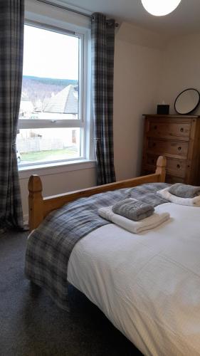 A bed or beds in a room at The Dookit - Aviemore Town House