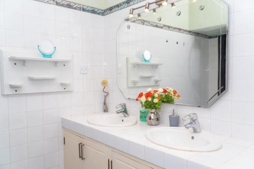 a bathroom with two sinks and a mirror at Amani Paradise - Luxury Villas in Diani Beach