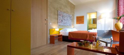 ein Hotelzimmer mit einem Bett, einem Schreibtisch und einem Zimmer in der Unterkunft Le Notti in Villa in Fontanellato