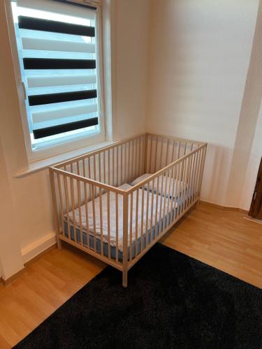 a crib in a room with a window at Ferienwohnung Eichhörnchen in Suhl