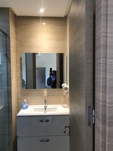 a bathroom with a sink and a mirror at Au Rez de jardin, Bel appt au sein du golf Montgomery in Marrakesh