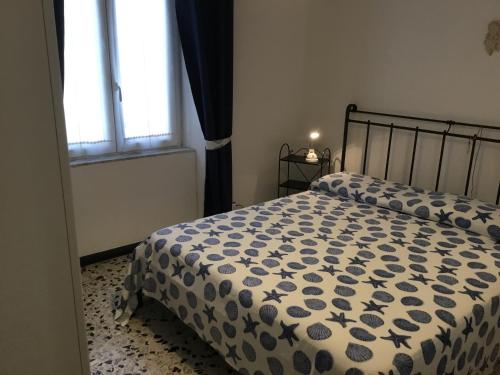 a bedroom with a bed with a blue and white comforter at Stella Marina delle 5 Terre in Levanto