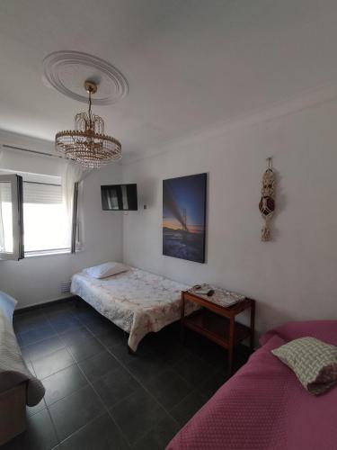 a bedroom with a bed and a chandelier at Bem Me Quer in Almada