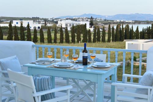 una mesa con copas de vino en el balcón en Tonia Apartments Paros, en Chrissi Akti