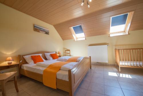een slaapkamer met een bed in een kamer met ramen bij Haus Engel in Burg-Reuland