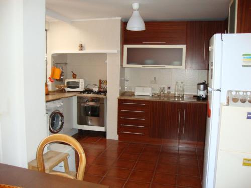 a kitchen with a refrigerator and a table with chairs at Simply Bairro Alto in Lisbon