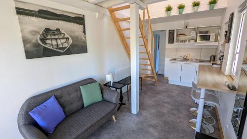 un salon avec un canapé et un escalier dans l'établissement Studio Mezzanine Chez Papou, Ville et Forêt, à Strasbourg