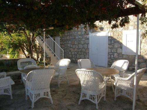a group of white chairs and a wooden table and chairs at Apartments Adriana in Bol