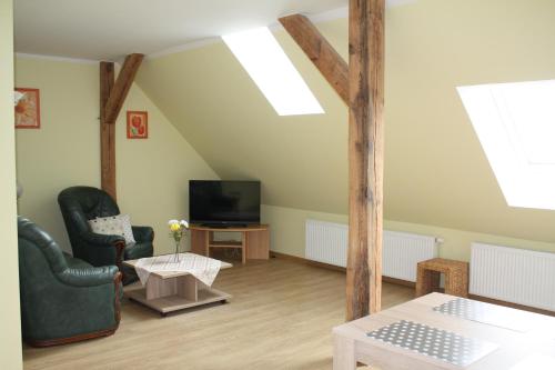 ein Wohnzimmer mit 2 Stühlen und einem TV in der Unterkunft Ferienwohnung am Schlosssee. in Penkun