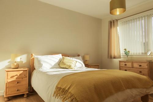 een slaapkamer met een bed, een dressoir en een raam bij No 4 the Highlands in Strathpeffer