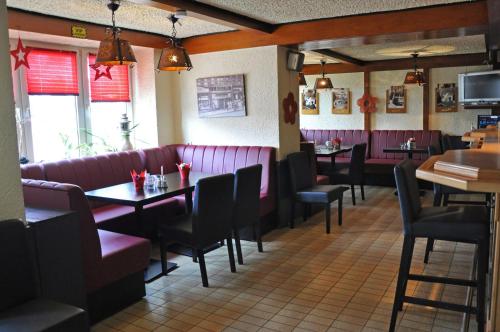 a dining room with purple booths and tables in a restaurant at Hotel am Ceresplatz in Manderscheid