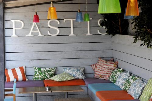 a bench with colorful pillows and a sign that says raisin at Le Jardin d'Emile in Cassis