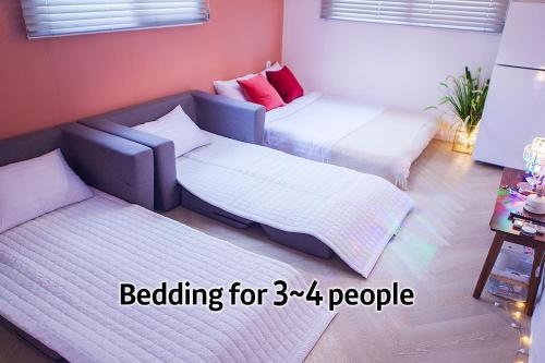 a room with two beds and a couch at Hostel Mihojae Seomyeon in Busan